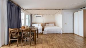 a bedroom with a table and a bed and a table and chairs at Yangyang Verit Pension in Yangyang +13 photos