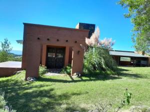a small brick house with a grass yard at Iorana in Villa Berna +3 photos