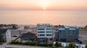 an aerial view of a hotel and the ocean at sunset at Yangyang Verit Pension in Yangyang