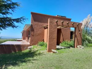 a brick house with an arch in the grass at Iorana in Villa Berna