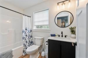 a bathroom with a toilet and a sink and a mirror at New Riverside Fire Pit 3BR 2.5 bath in Brewer +37 photos