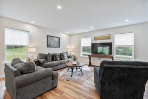 a living room with two couches and a flat screen tv at New Riverside Fire Pit 3BR 2.5 bath in Brewer