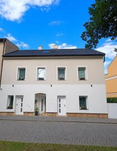 a large white house with a driveway at SLO. Apartments in Bakov nad Jizerou