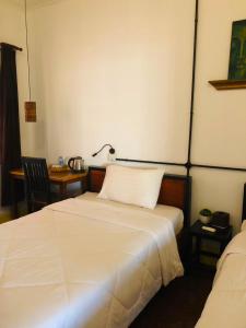 a bedroom with two beds and a table with a lamp at Phum Angkor in Siem Reap