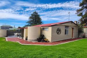 a small house with a green lawn at Jack's Tidal Pool Shack in Kingscote