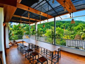 a dining room with a table and chairs and a balcony at Moonstone Holiday Cottages in Badulla