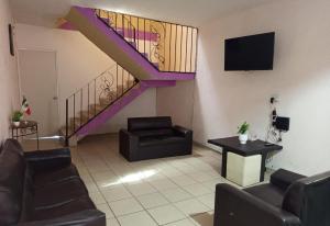a lobby with a staircase with chairs and a table at Amueblados Casa Conchita in León