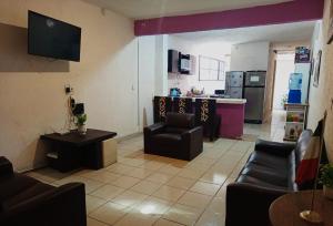 a living room with couches chairs and a kitchen at Amueblados Casa Conchita in León
