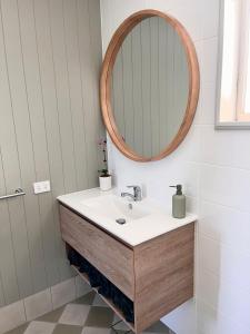 a bathroom with a sink and a mirror at Cedarvale Cottage in Boambee +34 photos