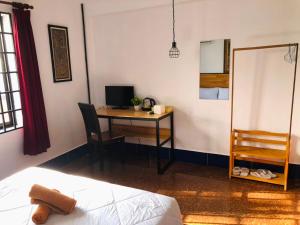 a bedroom with a desk with a computer and a bed at Phum Angkor in Siem Reap