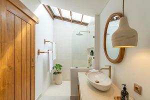 a bathroom with a sink and a mirror at SUMA Bali in Uluwatu +40 photos