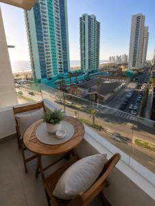 a table and chairs in a room with a large window at Nómade Summer Home in Iquique