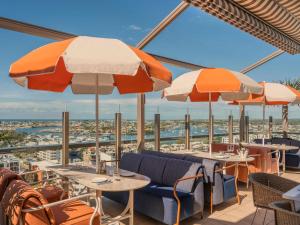 a restaurant with tables and chairs and umbrellas at Avani Mooloolaba Beach Hotel in Mooloolaba