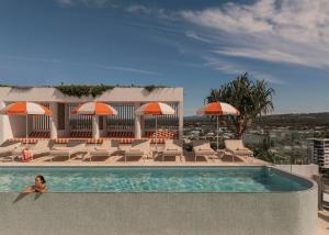 a woman sitting in a swimming pool at a hotel at Avani Mooloolaba Beach Hotel in Mooloolaba