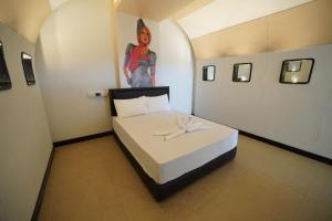 a room with a bed with a picture of a woman on the wall at โรงแรมทูมอร์โรว์แลนด์ อมตะนคร in Ban Khlong Phan Thong
