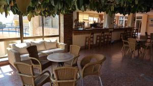 a restaurant with a couch and chairs and a bar at Hotel Bahía by ALEGRIA in Puerto de Mazarrón