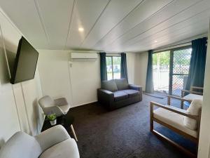 a living room with a couch and a chair at Young Tourist Park in Young