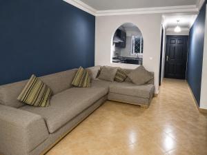 a living room with a couch and a blue wall at Résidence Tarifa in Mrarech +5 photos
