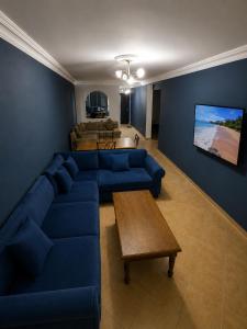 a living room with a blue couch and a table at Résidence Tarifa in Mrarech