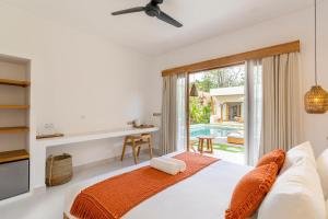 a bedroom with a bed and a view of a pool at SUMA Bali in Uluwatu