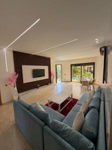 a living room with a blue couch and a table at Rose Garden Resort & Spa in Marrakesh