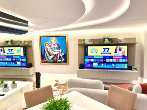 a living room with two televisions and couches at Duplex de luxo em Belem in Belém