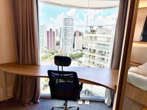a desk in a room with a large window at Duplex de luxo em Belem in Belém +37 photos