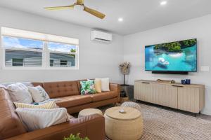 a living room with a couch and a flat screen tv at Neptunes Hideaway in Vero Beach