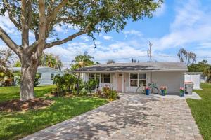 a small white house with a tree in the yard at Neptunes Hideaway in Vero Beach