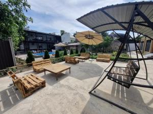 a patio with wooden benches and an umbrella at Apricot Lodge in Bishkek