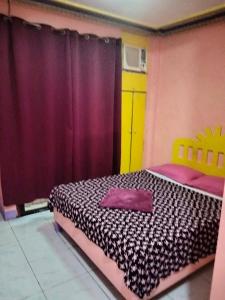 a bedroom with a bed and a purple curtain at Janisah Pension House in Narra