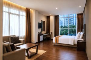 a hotel room with a bed and a living room at Oria Hotel Jakarta in Jakarta +77 photos