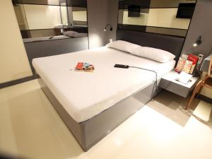 a large white bed in a room with a mirror at Hotel Sogo Edsa Cubao in Manila