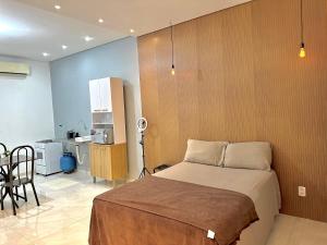 a bedroom with a bed and a table and a kitchen at Garagem, Pátio Privativo - Apartamento Completo Moderno in Campo Novo do Parecis