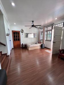 a large living room with a ceiling fan and wooden floors at Harmoni Group Stay in Bintulu