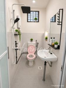 a bathroom with a pink toilet and a sink at Harmoni Group Stay in Bintulu +8 photos