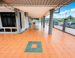 an empty building with a tile floor and columns at Harmoni Group Stay in Bintulu