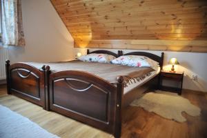 uma cama de madeira num quarto com tecto de madeira em "Pod Szumiącą Topolą" em Białowieża