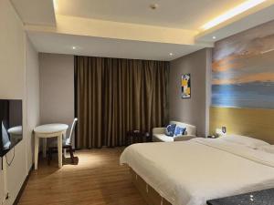a hotel room with a large bed and a table at Wanyi Hotel in Dongguan