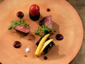 a plate of food with meat and vegetables on it at Tateshina Lake Resort in Tateshina