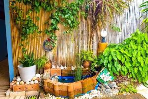 a small garden with a small pond with plants at Pailin Hotel Krabi in Klong Muang Beach