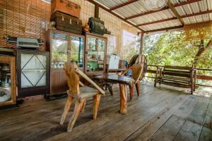 a dining room with a table and chairs on a wooden floor at Tong Hotel in Ban Nong Chik