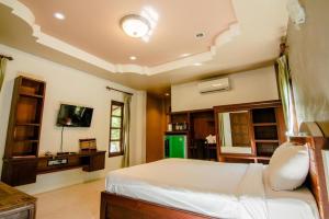 a bedroom with a bed and a tv in a room at Tong Hotel in Ban Nong Chik