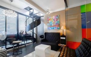 a living room with a black chair and a colorful wall at Hotel Monde in Dagupan