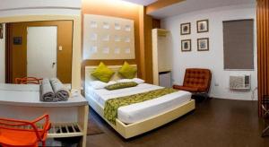 a bedroom with a large bed and a desk in it at Hotel Monde in Dagupan