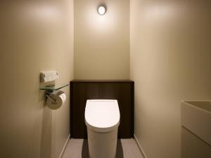 a small bathroom with a toilet with a light on the wall at SHIFT HOTEL Shibuya Jinnan in Tokyo +24 photos
