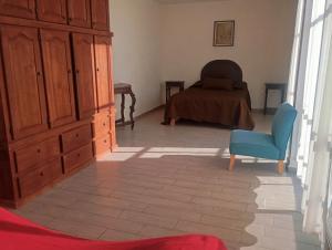 ein Zimmer mit einem Schlafzimmer, einem Bett und einem blauen Stuhl in der Unterkunft Casa LM in San Miguel de Allende