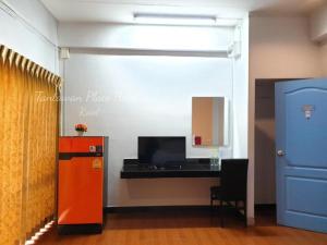 a kitchen with an orange refrigerator and a desk at Tantawan Place in Roi Et