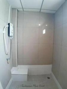 a bathroom with a shower with a phone on the wall at Tantawan Place in Roi Et +23 photos