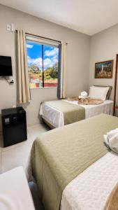 a hotel room with two beds and a window at Pousada Coco Babaçu in Viçosa do Ceará +179 photos